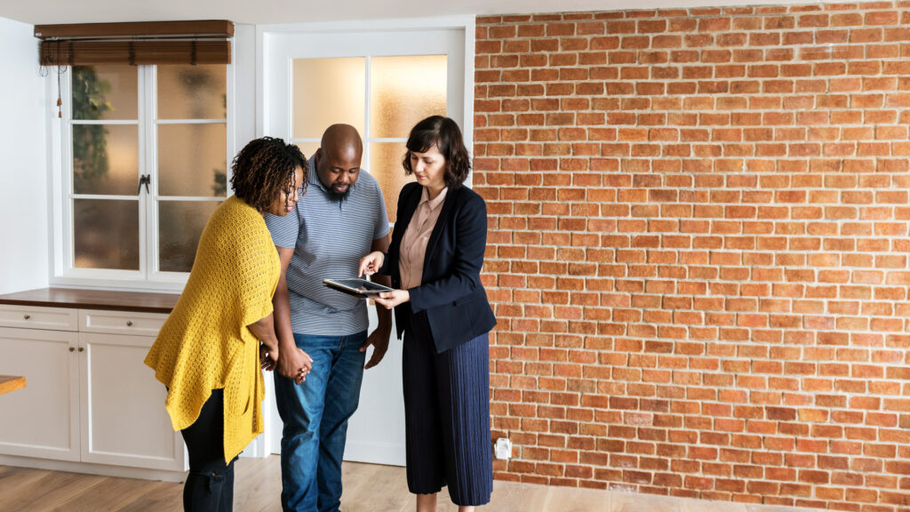 family talking to estate agent outside house