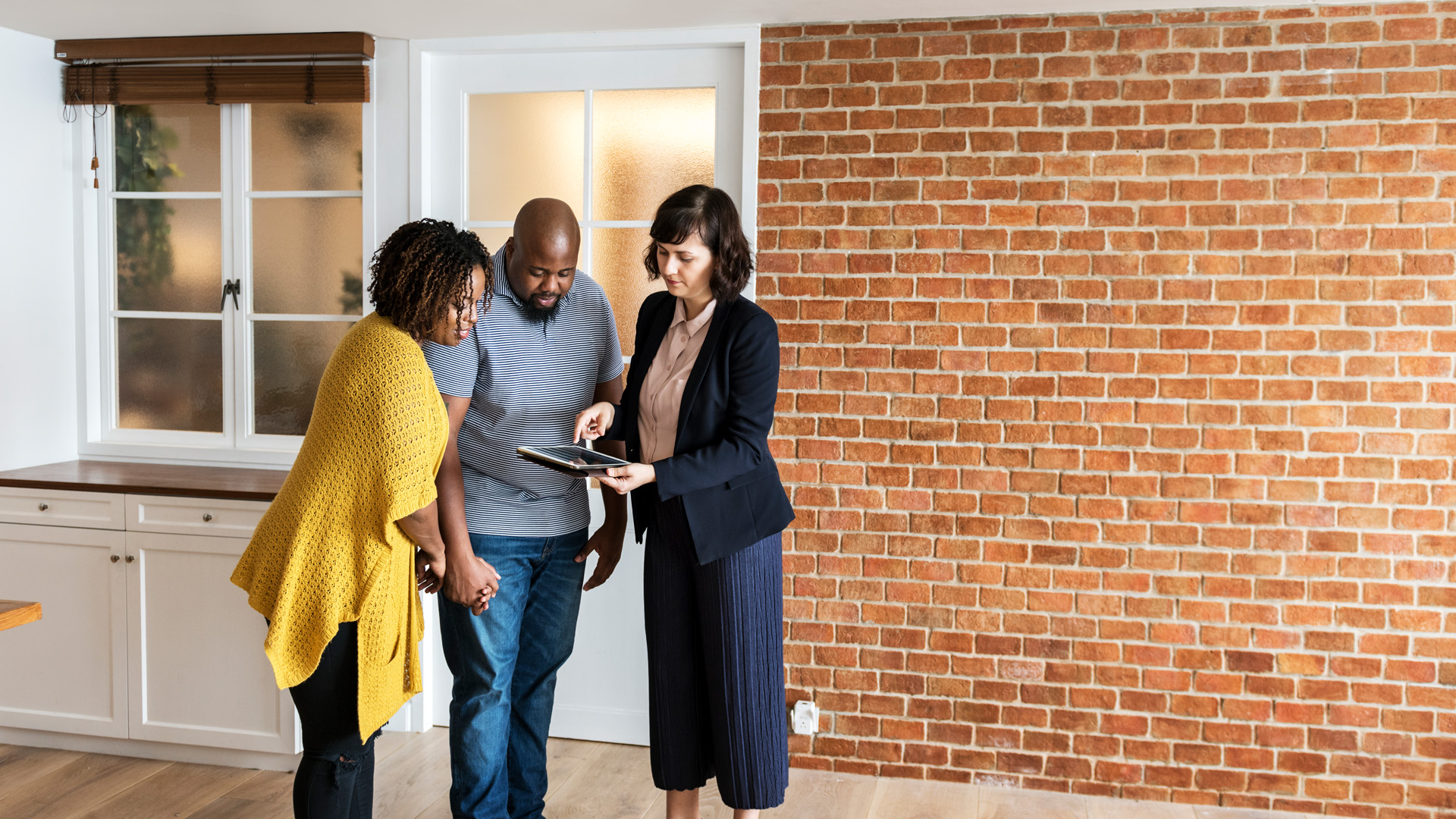 family talking to estate agent outside house